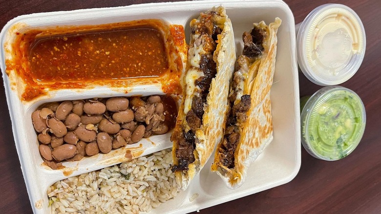 A Chipotle quesadilla meal with sour cream and quacamole on the side