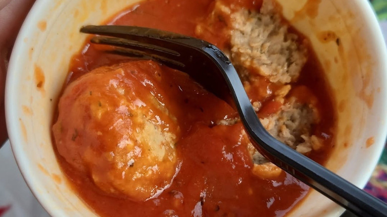 Close-up of a Wawa container of meatballs and sauce.
