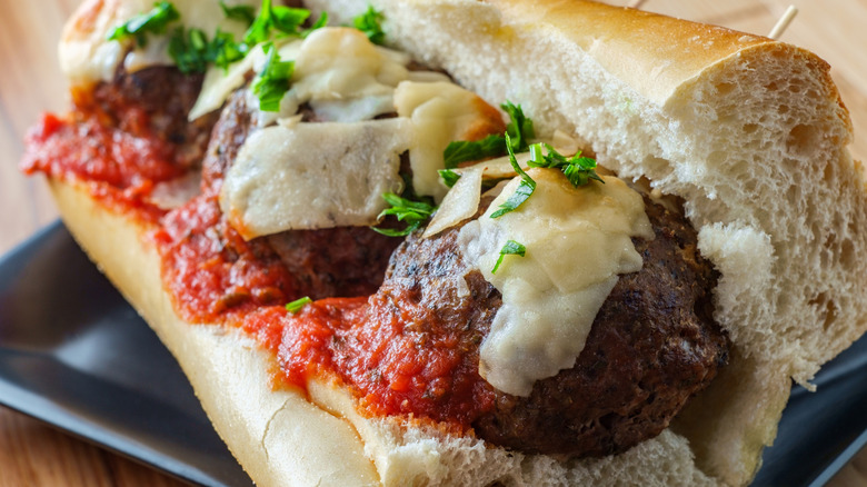 Close-up of a meatball sub with parsley on top.