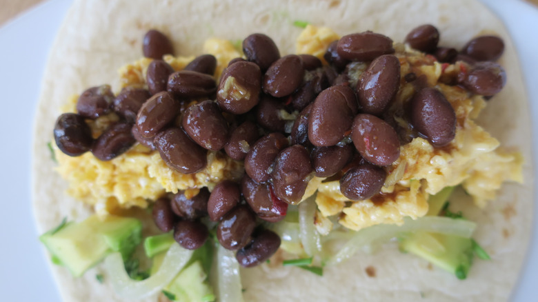 Black beans and scrambled eggs on a tortilla