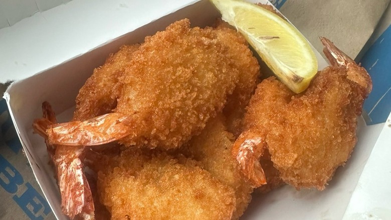 Culver's jumbo butterfly shrimp sit in a cardboard container with a slice of lemon