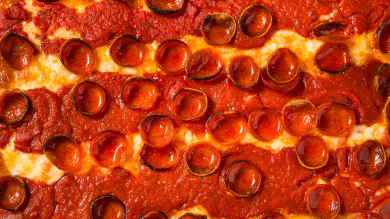 A Detroit-style pepperoni pizza with sauce on top of the cheese