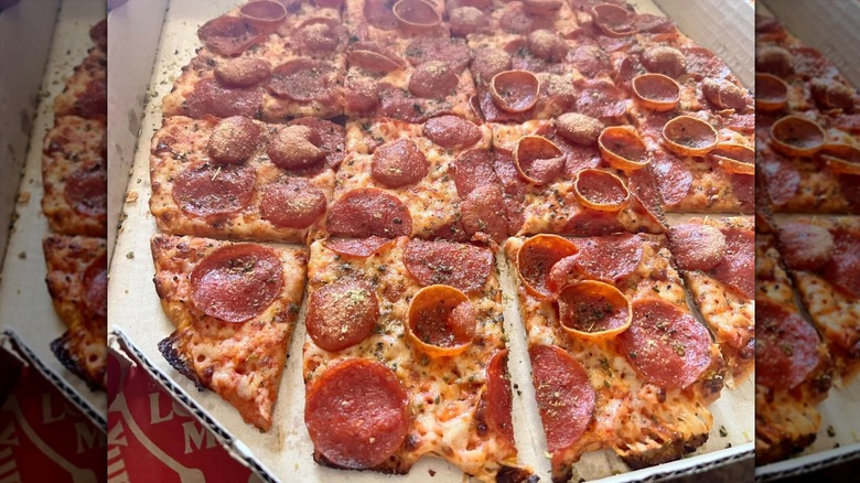 A Pizza Hut tavern-style pizza with pepperoni and cheese, dusted with Hut Dust