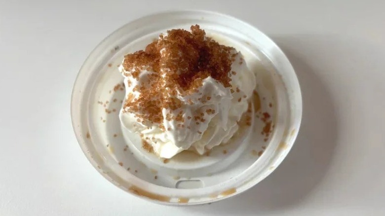 An overhead view of a Starbucks beverage topped with whipped cream and Salted Brown-Buttery Topping