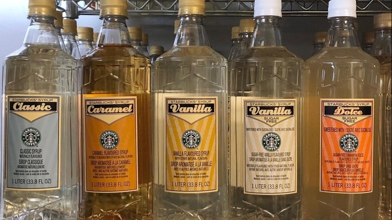 Five bottles of different Starbucks syrup flavors lined up in a row