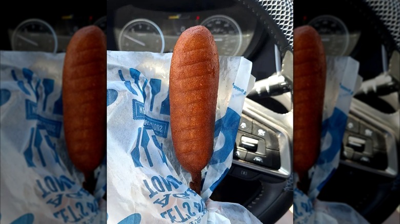 Corn dog from Culver's on a stick wrapped in white and blue wax paper