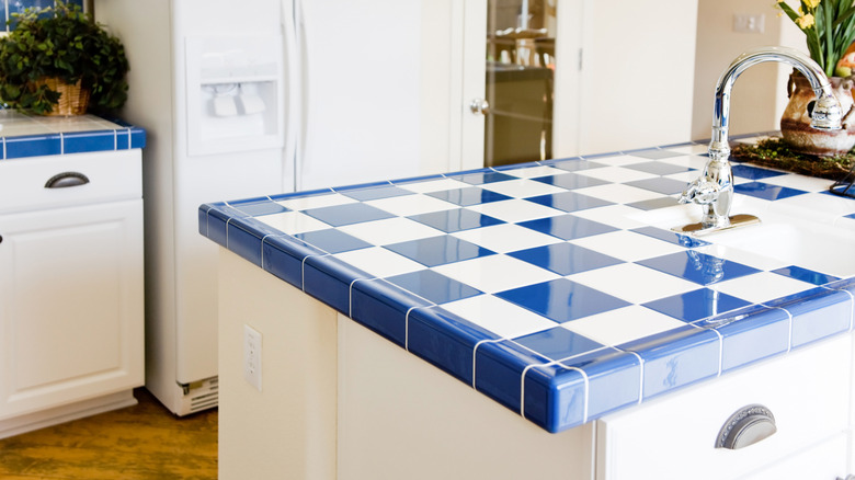 Modern kitchen island with blue and white tiled countertop