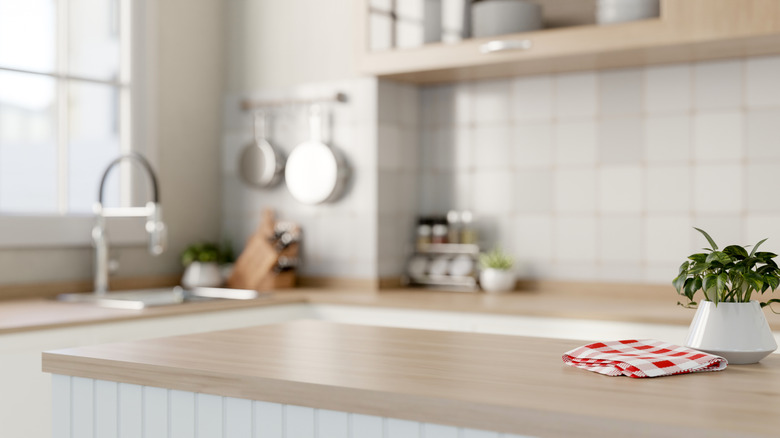 Beige kitchen countertop with checkered cloth and a plant