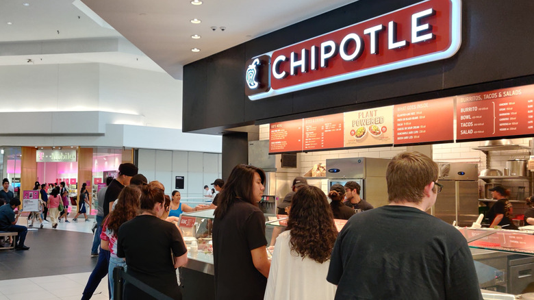 Chipotle located inside of a mall with people waiting