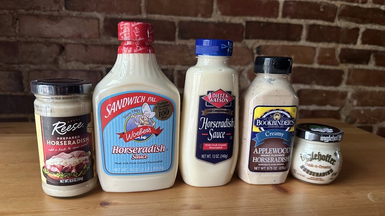 Five bottles of horseradish on wooden table