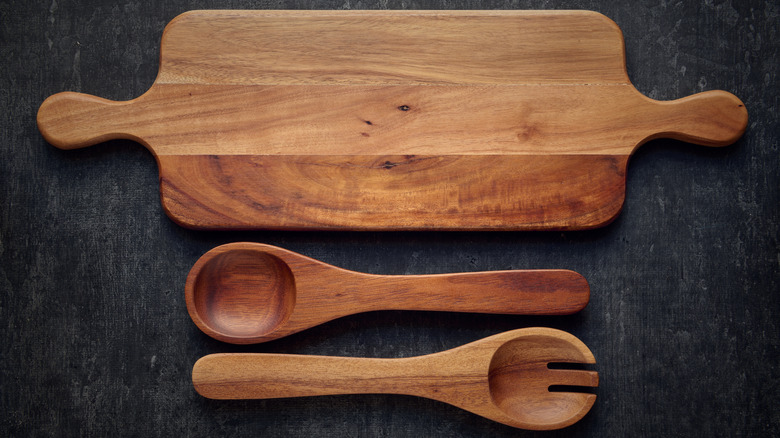 A long serving board and two serving utensils, all made from acacia wood