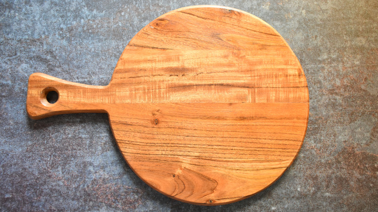 Round serving tray with a handle, made from acacia wood