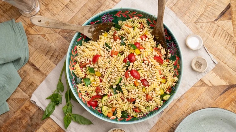 Summer Garden Pasta Salad in colorful bowl with wooden spoons