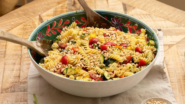 Summer Garden Pasta Salad in colorful bowl with wooden spoons