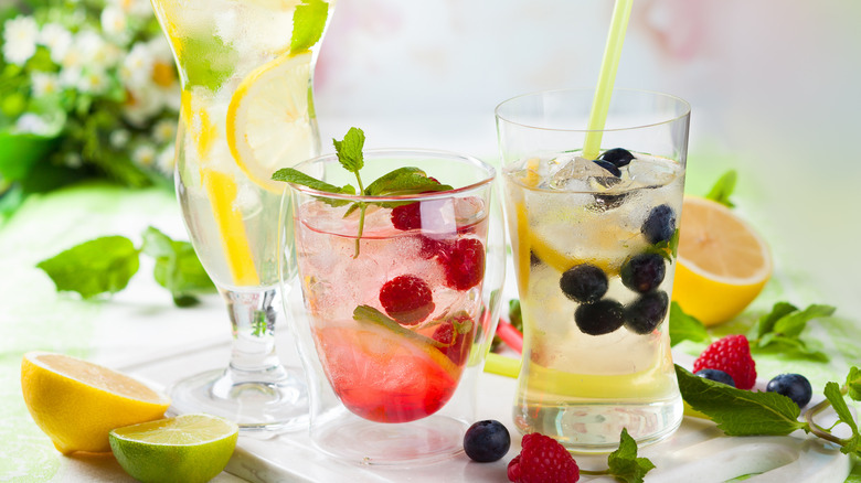 Three glasses of iced liquid, with mint and blueberries