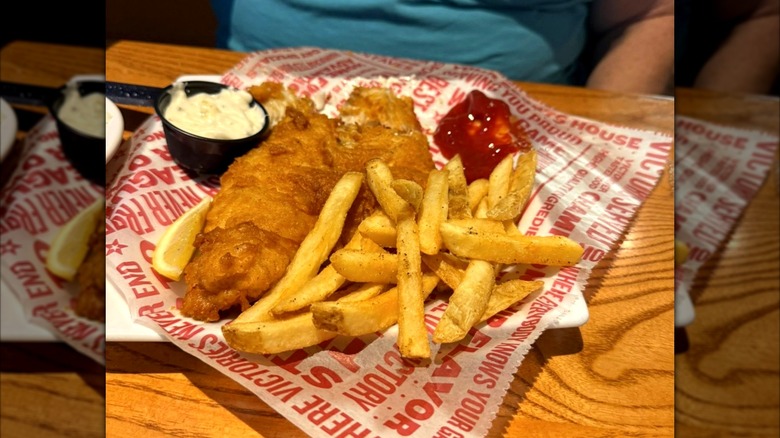 plate of fish and chips from Glory Days Grill with lemon wedge, ketchup, and black cup of tartar sauce