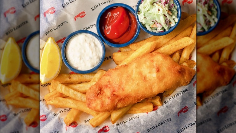 Fish and chips dish from Red Lobster with lemon wedge and blue cups of sauces and coleslaw