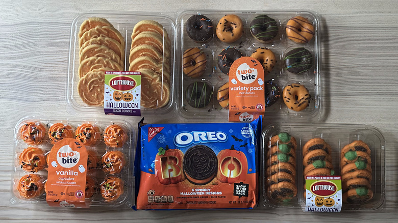 Packages of baked Halloween treats arranged on wooden table
