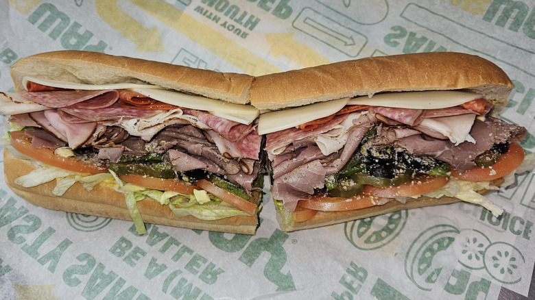 A 12-inch Subway 5 Meat Italian sub sitting a Subway paper