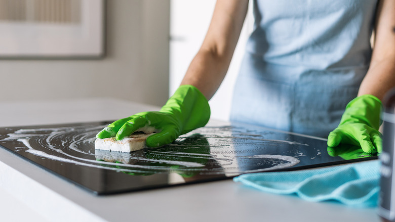 Woman cleaning a induction cooktop