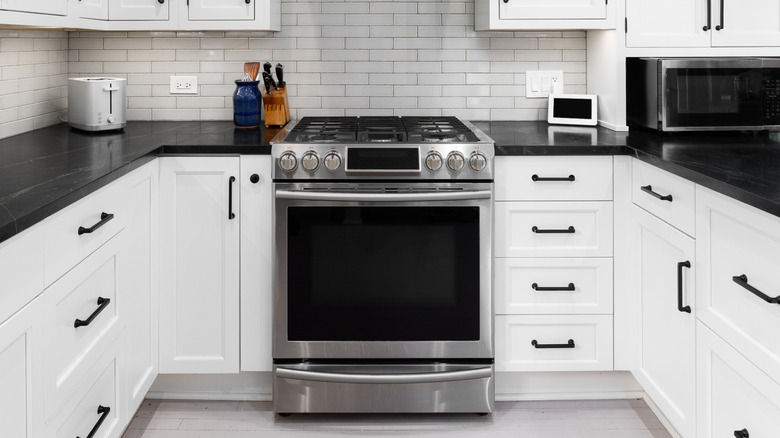 A modern kitchen with a stainless steel oven and range with a warming drawer on the bottom