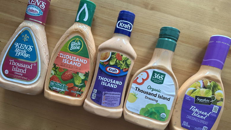 Bottles of thousand island dressing on wooden table