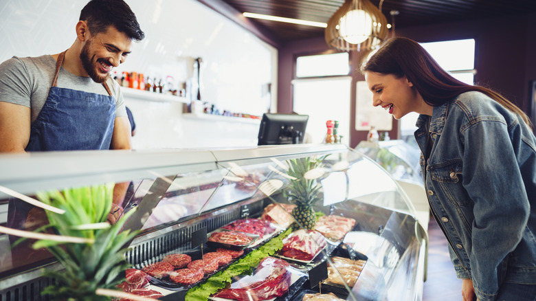 Butcher helping customer choose meat