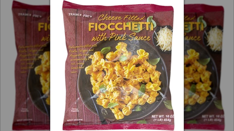 Table laden with cheese filled fiocchetti with pink sauce on plate alongside packaging