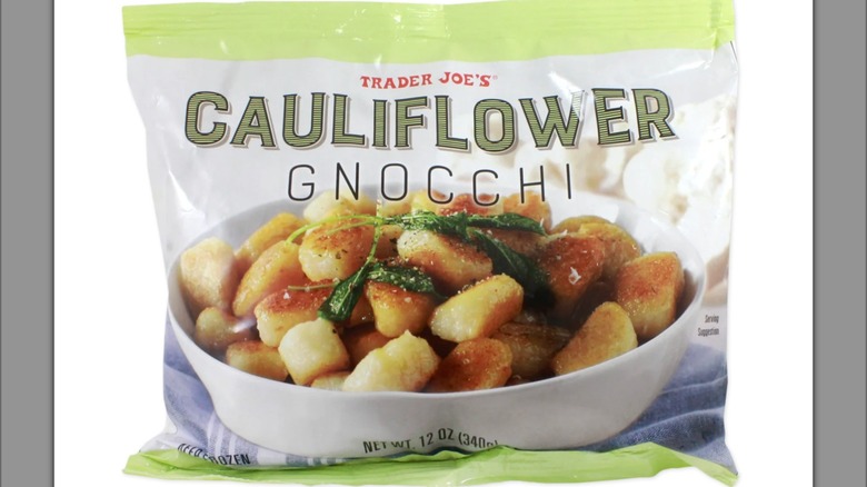 Cauliflower gnocchi and peas on plates alongside product packaging and wine on table