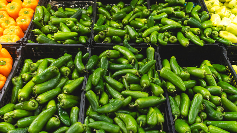 Boxes of fresh green jalapeños at the grocery store.