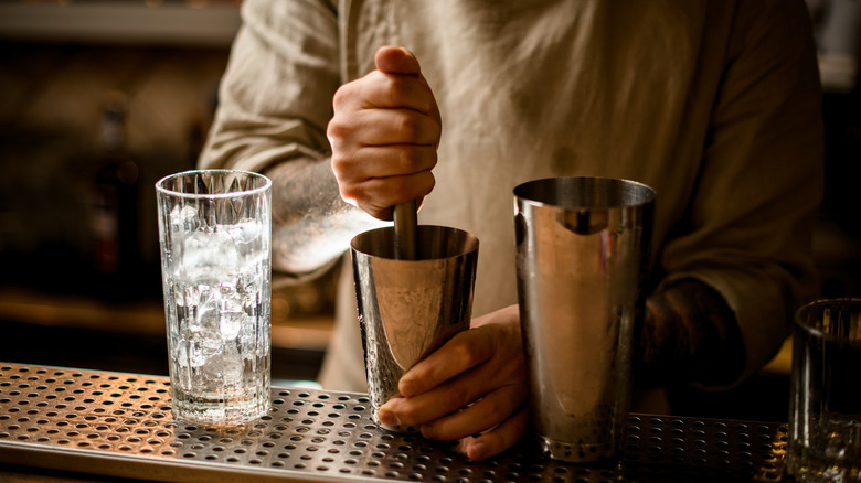Bartender muddling drinks