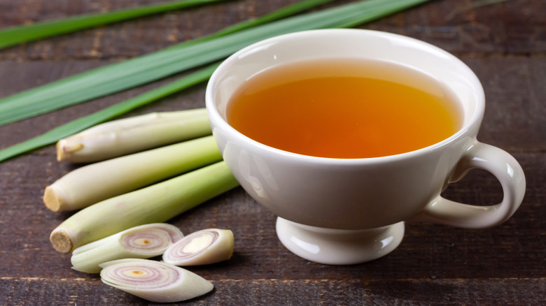 White cup with lemongrass tea and stalks of lemongrass