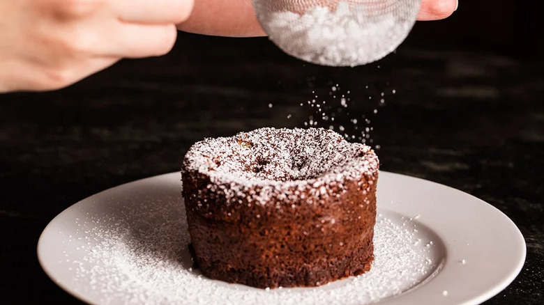 chef decorating cake with sugar