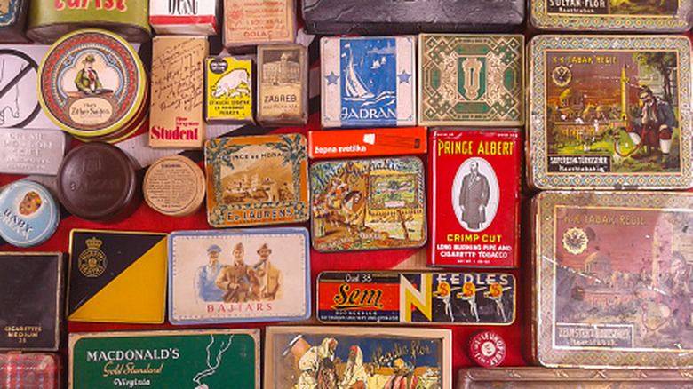 Vintage tin cans with assorted colorful labels flat on a table.