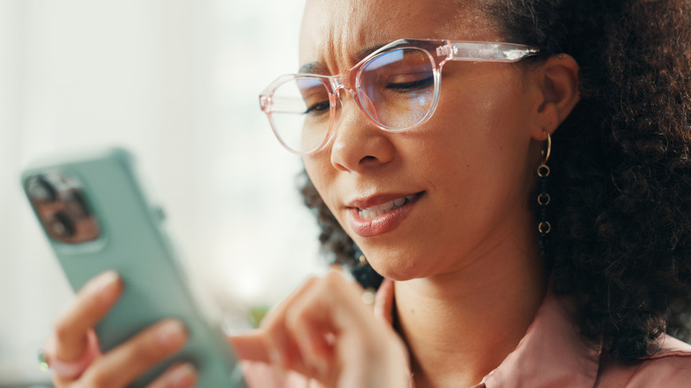 confused woman looking at phone