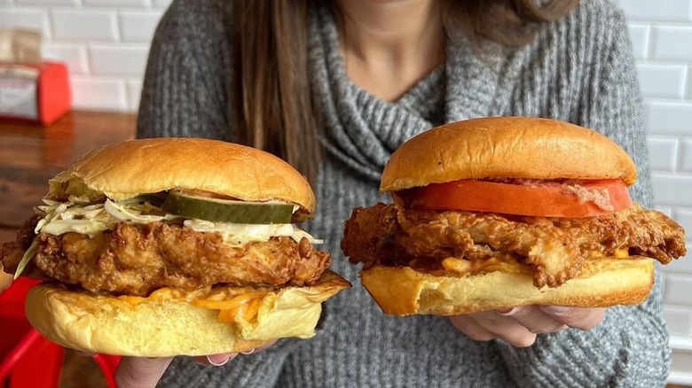 Woman holding two chicken sandwiches
