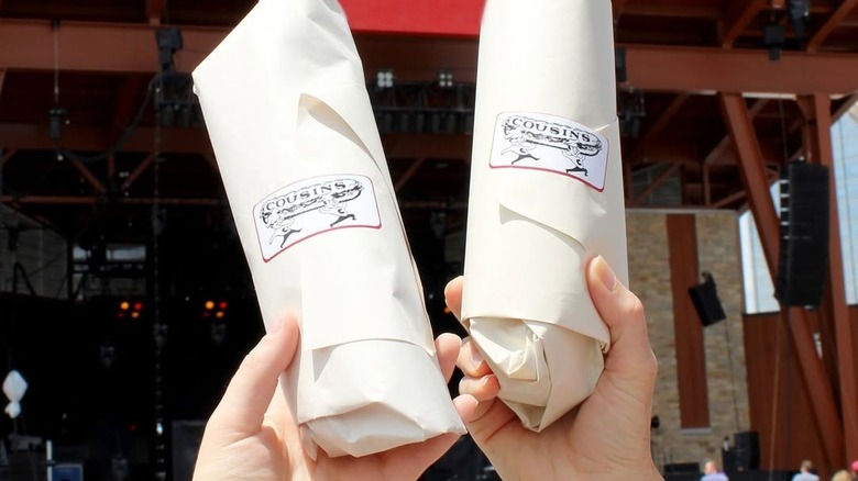 Cousins Subs sandwiches being held in the air