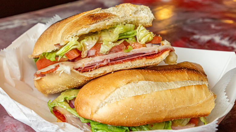 Two sandwiches unwrapped on a tray