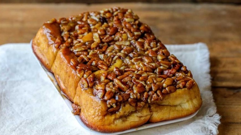 Close-up of Pecan Sticky Buns on white cloth on wooden table
