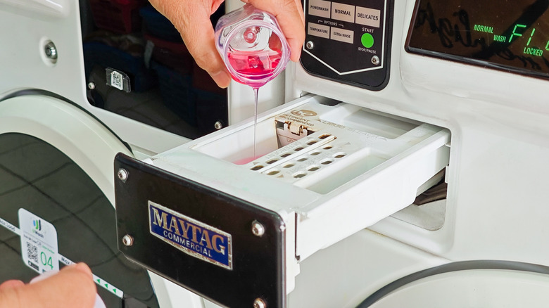 Detergent being poured into a Maytag washer