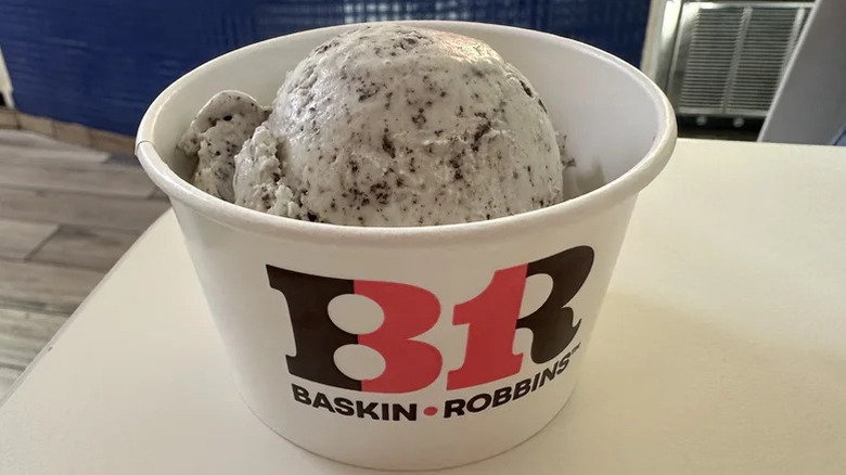 A scoop of Baskin Robbins mint chip ice cream in a paper cup