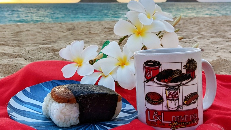 Spam Musubi on a blanket at the beach with coffee mug and flowers
