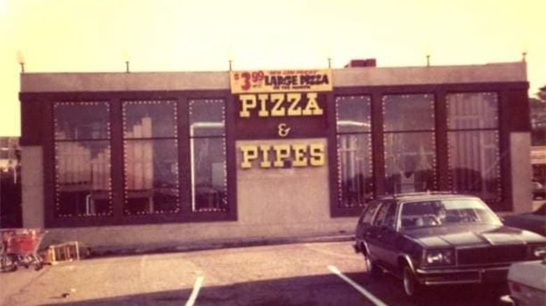old photo of the outside of Pizza & Pipes restaurant with car parked outside