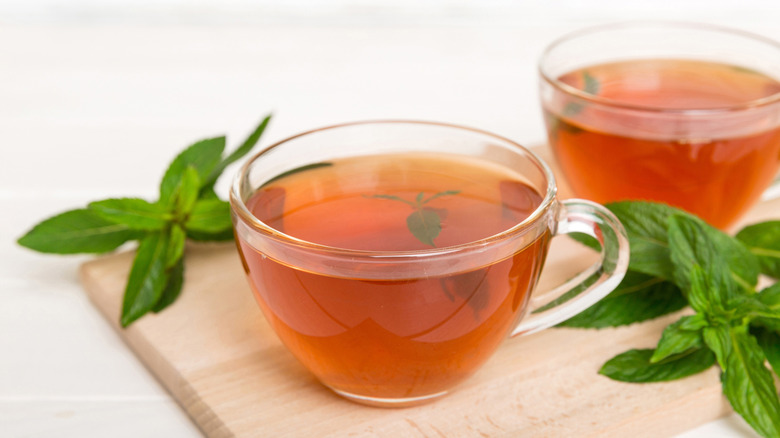 Spearmint leaves alongside a cup of mint tea