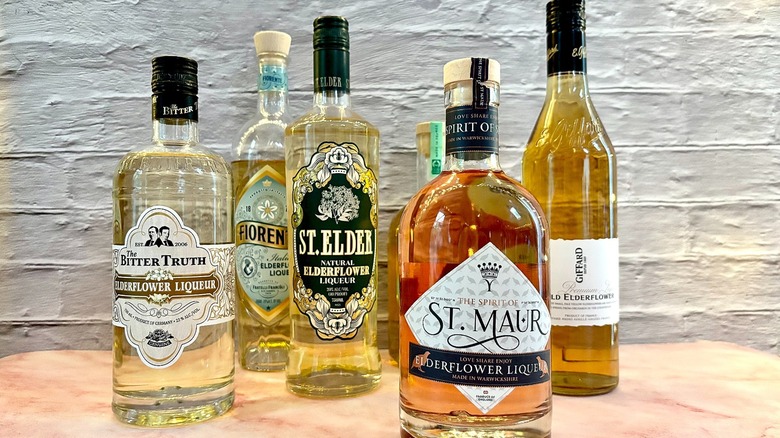 Bottles of Elderflower liqueur on pink table
