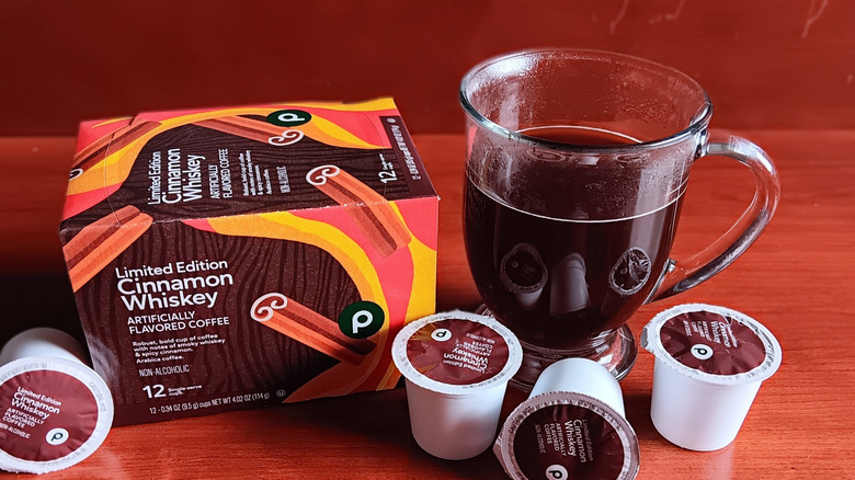 Box of Publix Cinnamon Whiskey flavored coffee K-cups with mug of black coffee
