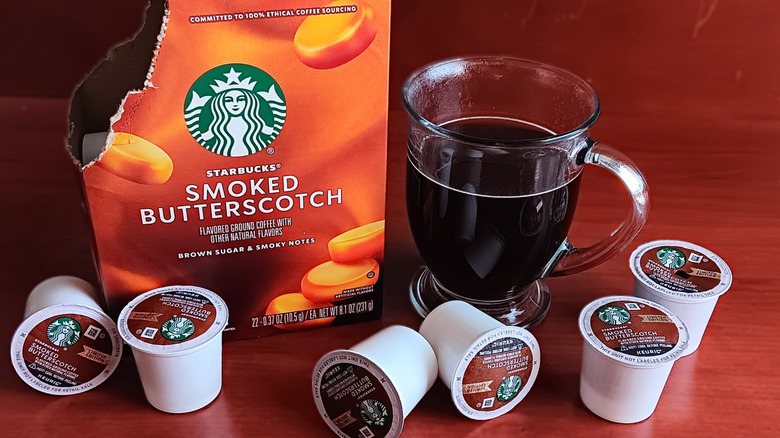 Open box of Starbucks Smoked Butterscotch flavored coffee K-cups with mug of black coffee