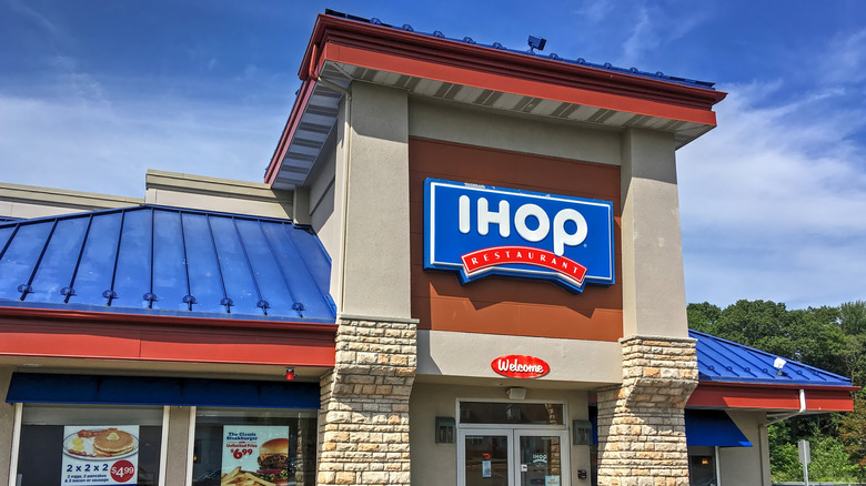 A blue-roofed IHOP restaurant, showing the white-and-red logo on a blue sign above its entrance.