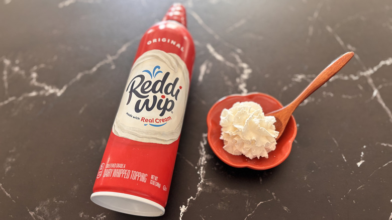 Reddi-wip whipped cream can next to small bowl of whipped cream