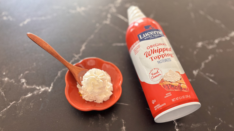 Small bowl of whipped cream next to Lucerne Farms whipped cream can